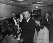 Lyndon Johnson being sworn in as President aboard Air Force I, beside Jacqueline Kennedy.