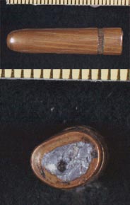 Views of side and base of Commission Exhibit 399. The nick in the base was caused by the FBI when removing lead for testing. The bullet is squeezed but otherwise undamaged.